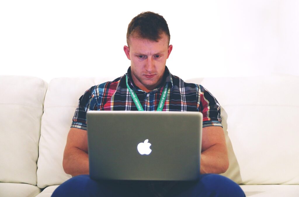 IT-zzp'er die werkt aan een laptop thuis en algemene voorwaarden controleert