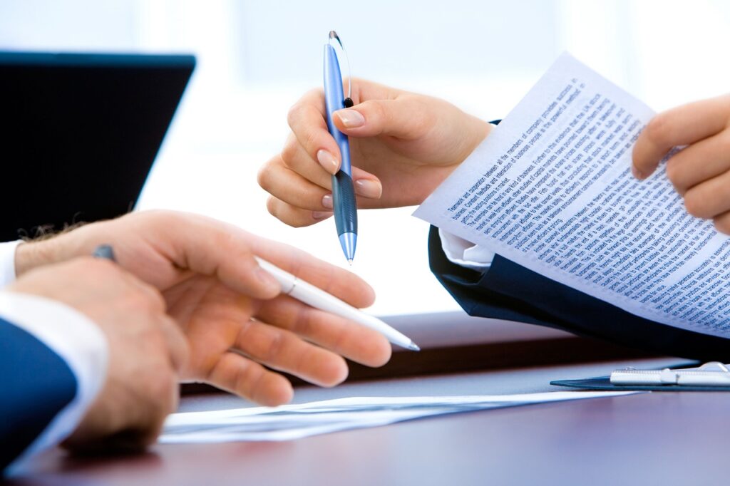 Fotograaf die een contract met algemene voorwaarden doorneemt aan een bureau